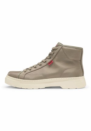 High-top sneakers in beige fabric with a textured finish, white sole, and red logo accent. Features lace-up closure and padded collar.