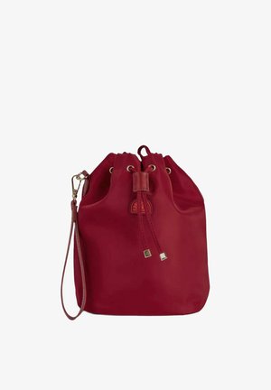 Borsa a secchiello in pelle rossa con coulisse, cinturino da polso e piccolo logo impresso sul davanti su sfondo bianco.