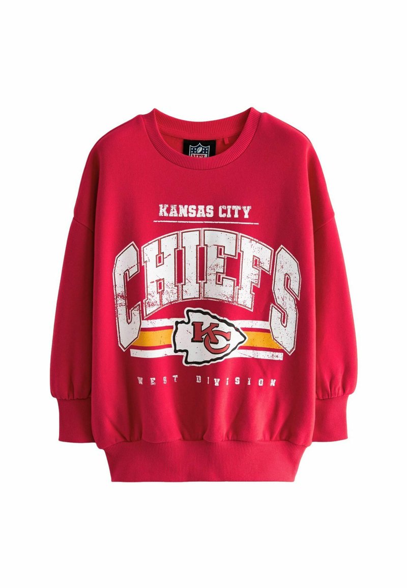 Piros pulóver hosszú ujjal, a "KANSAS CITY CHIEFS" felirattal, logóval és a "WEST DIVISION" felirattal, megkopott fehér és sárga kiegészítőkkel.
