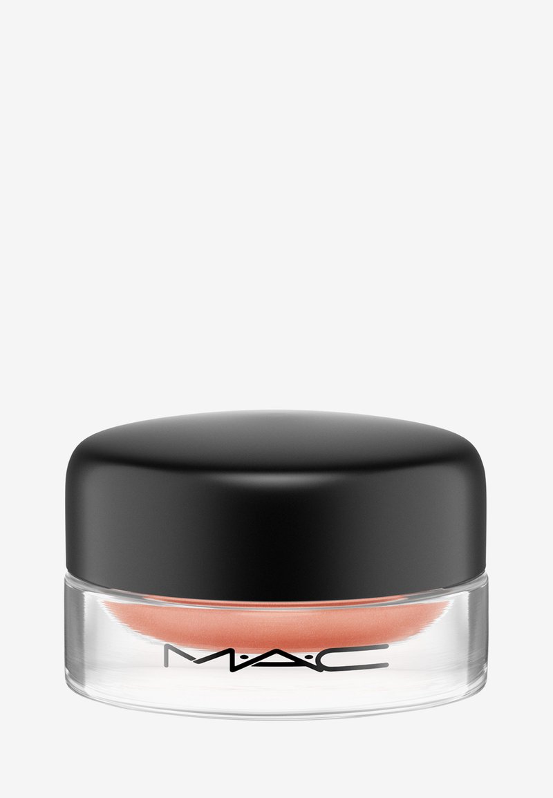 Produit MAC dans un pot en verre transparent avec un couvercle noir, contenant une crème de couleur pêche. Texture lisse visible à travers le contenant transparent.