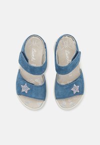 Blå ruskind-sandaler med to justerbare stropper, en tekstureret indersål og en rhinstenstjerne-accentside. Let hvid sål.