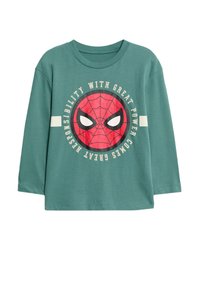 Green long-sleeve t-shirt featuring a central red spider graphic with wide white eyes, text reading "WITH GREAT POWER COMES GREAT RESPONSIBILITY."