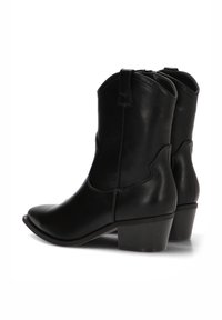 Botas de cowboy de cuero negro con punta afilada, tacón bajo de bloque y tiradores. Textura lisa con un diseño aerodinámico y acentos mínimos.