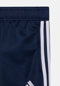 Marineblaue Sportshorts mit einem elastischen Bund, ausgestattet mit weißen drei Streifen Akzenten und einer strukturierten Stoffoberfläche.
