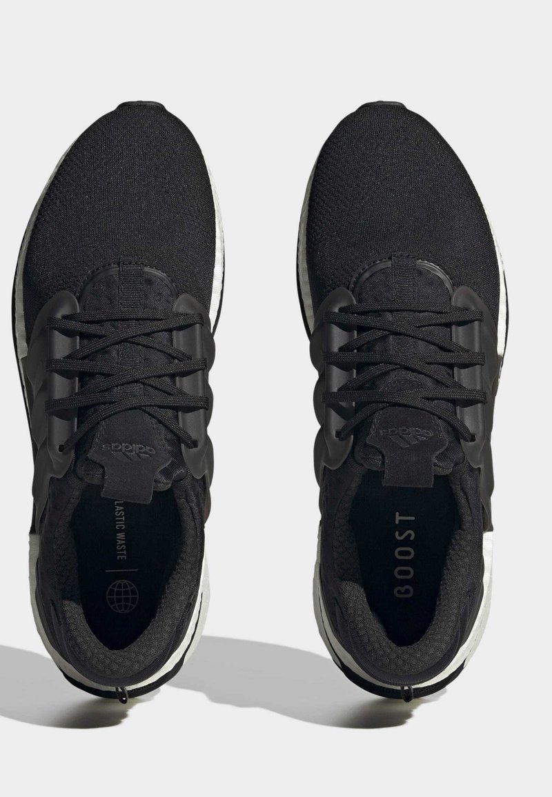 Schwarze Sport Schuhe mit einem Mesh-Obermaterial, strukturierten Schnürsenkeln und einer markanten weißen Boost-Sohle. Mit Branding auf der Zunge und der Innensohle.