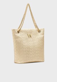 Sac fourre-tout texturé doré avec un motif floral, doté de poignées en chaîne et d'un logo "W" bien en vue sur le devant.