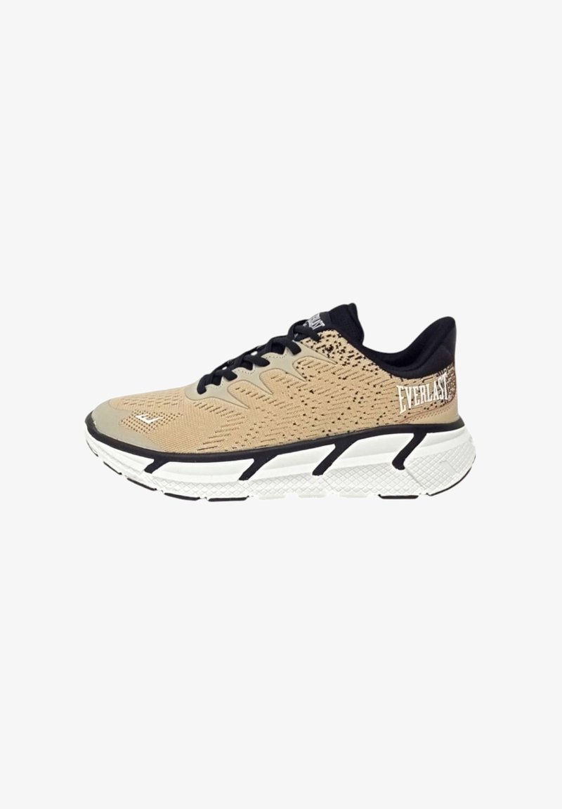 Scarpa atletica beige con tomaia in rete testurizzata, dettagli neri, lacci e una suola bianca e imbottita con un design a motivi. Logo sul tallone.