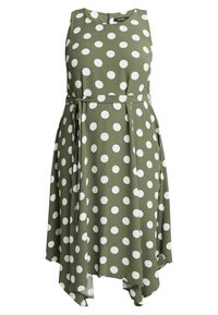 Grünes Kleid mit weißen Punkten, ärmelloses Design, Gurt an der Taille und asymmetrischer Saum. Hergestellt aus glattem Stoff.