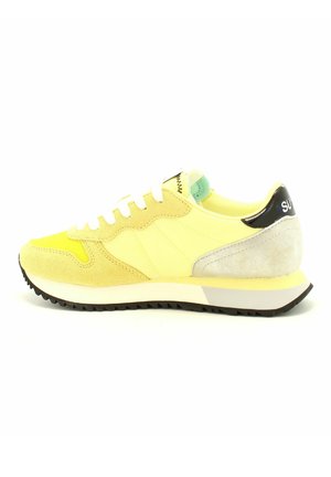 Sneaker giallo con parte superiore in suede e rete, lacci bianchi, pannello posteriore grigio chiaro e accentuazione nera sul tallone. Suola in gomma con battistrada testurizzato.