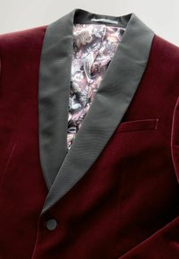 Burgundi bársonykabát fekete selyem stólakollárral és virágmintás selyem béléssel. Egyszeres gomb és zsebdísz.