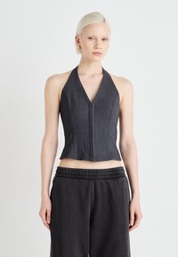 Mørkegrå halterneck-top med en tætsiddende design, dyb V-udskæring og lukning foran. Stoffet har en glat tekstur og en struktureret form.