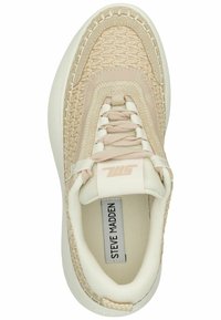 Beige sneakers med teksturerede, vævede accenter, glatte læderlignende overlays og en chunky hvid sål. Har snørebånddesign og logo-detalje.
