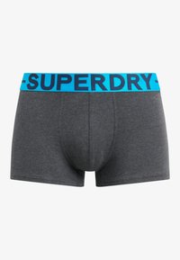 Boxers ajustados de algodón gris con una cinturilla elástica azul que lleva el logo de "SUPERDRY". Textura suave, diseño ceñido y largo hasta medio muslo.