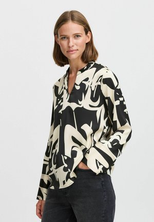 Long-sleeve blouse in black and cream with abstract patterns. Features a V-neckline and smooth, lightweight fabric.