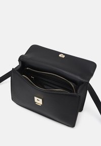 Černá kožená kabelka na crossbody s texturovaným povrchem, zlatým kováním a předním klopovým zapínáním. Vnitřek obsahuje několik přihrádek a zipů.