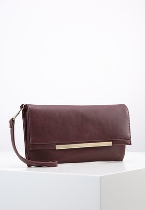 Pochette en simili cuir bourgogne avec un rabat, dotée d'une bande décorative en métal doré et d'une lanière pour un transport facilité.