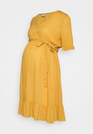 Gele, knielange zwangerschapsjurk van geplooide stof met een V-hals, korte gerimpelde mouwen en een strikceintuur in de taille. Ruches aan de zoom.