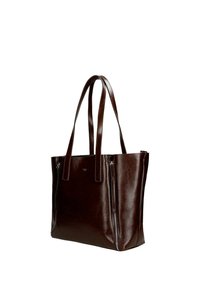 Hnědá kožená taška přes rameno s dvěma dlouhými uchy, hladkým povrchem a dvěma zipovými kapsami vpředu pro uložení věcí.