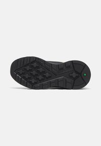 Semelle de chaussure noire avec motif de semelle multidirectionnel, talon arrondi, surface texturée et accent central vert. Matériau en caoutchouc durable.