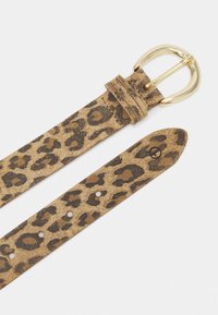 Ceinture en imprimé léopard, dans des teintes marron et beige, avec une boucle en métal doré. Matière douce au toucher avec plusieurs trous pour un ajustement facile.