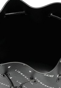 Borsa a secchiello nera in pelle liscia con bordo superiore ondulato. L'interno presenta un motivo a logo bianco, hardware minimale e senza tasche.