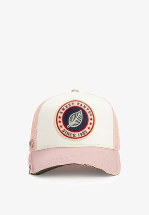 Casquette de camionneur blanche et rose avec un écusson circulaire représentant une feuille et le texte "SWEET PANTS SINCE 1982" entouré d'étoiles rouges.