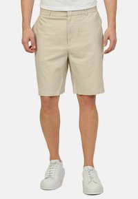 Bermuda in cotone beige con vita elastica, tasche laterali e vestibilità comoda. Abbinati a sneakers bianche per un look casual.
