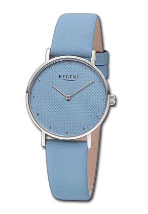 Montre ronde avec un cadran texturé bleu clair, des accents en argent et des marqueurs d'heure. Terminée par un bracelet en cuir bleu clair assorti.