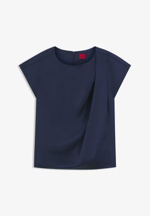 Haut à manches courtes bleu marine avec un col rond, détail drapé sur le devant et une fermeture éclair cachée à l'arrière. Texture de tissu lisse.