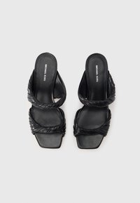 Sandali con zeppa in pelle nera con design a cinturino intrecciato, punta quadrata e texture liscia. Logo stampato sulla soletta.