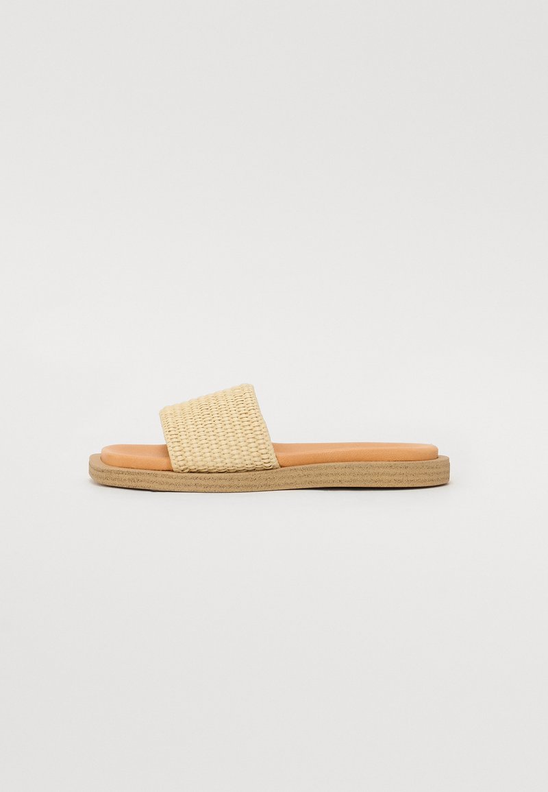 Woven beige slide sandal with a textured upper and a smooth tan insole. Flat sole with a subtle ridged edge. Lightweight design.