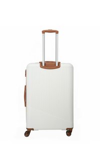 Valise rigide blanche avec une texture striée, des accents bruns, deux poignées télescopiques et quatre roues pour une mobilité aisée.