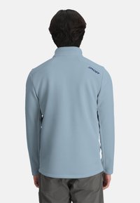 Lichblau fleece pullover met ribbeltextuur. Bevat een hoge kraag en een geborduurd merklargo in het blauw op de bovenrug. Lange mouwen.