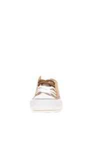 Beige stoffen sneaker met witte rubberen zool, voorzien van drie bruine en drie witte veters, en een gestructureerd design op het bovenwerk.