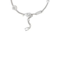 Bracelet en chaîne argentée avec un charme floral orné d'un cristal, un fermoir ajustable et une étiquette gravée. Texture lisse et design délicat.