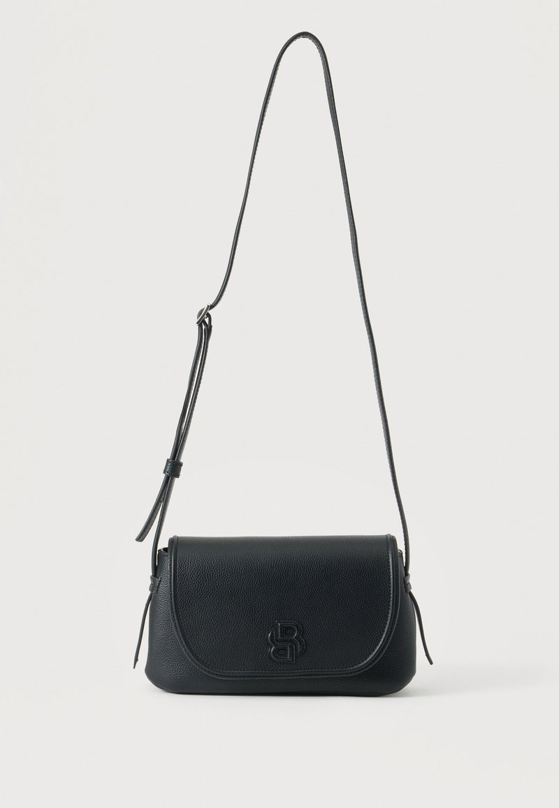 Sac à main bandoulière en cuir noir avec sangle réglable et logo embossé sur le rabat avant, présenté sur fond blanc.