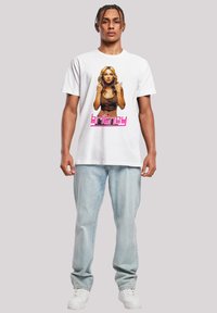 Witte katoenen t-shirt met een kleurrijke grafische print van een vrouw en het woord "britney" in het roze aan de onderkant. Draag het met lichtblauwe jeans.