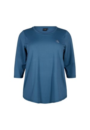 Chemise bleue à manches trois quarts, fabriquée en tissu lisse et léger. Elle présente un col rond et un logo subtil près du coin supérieur gauche.