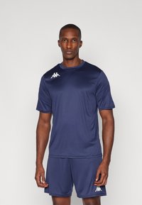 Camisa e calções atléticos azul-marinho feitos de um tecido que afasta a humidade, com um logotipo branco no lado esquerdo do peito e na lateral dos calções.