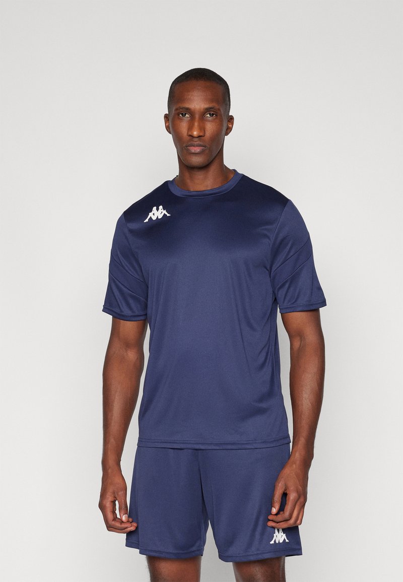 Camisa e calções atléticos azul-marinho feitos de um tecido que afasta a humidade, com um logotipo branco no lado esquerdo do peito e na lateral dos calções.
