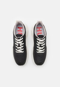 Sneaker sportive nere con tomaia in tessuto texturizzato, lacci bianchi e logo a contrasto rosso e bianco sulla soletta.