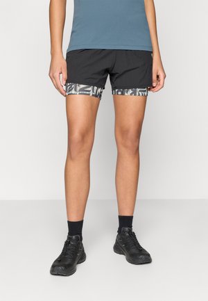 Czarne szorty sportowe z wzorowanym paskiem, w połączeniu z niebieską górą i czarnymi butami. Szorty wykonane są z lekkiego, teksturowanego materiału.