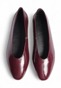 Ballerines en cuir verni bordeaux avec bouts ronds, finition lisse et doublure intérieure noire. Pas de quincaillerie ni de motifs visibles.