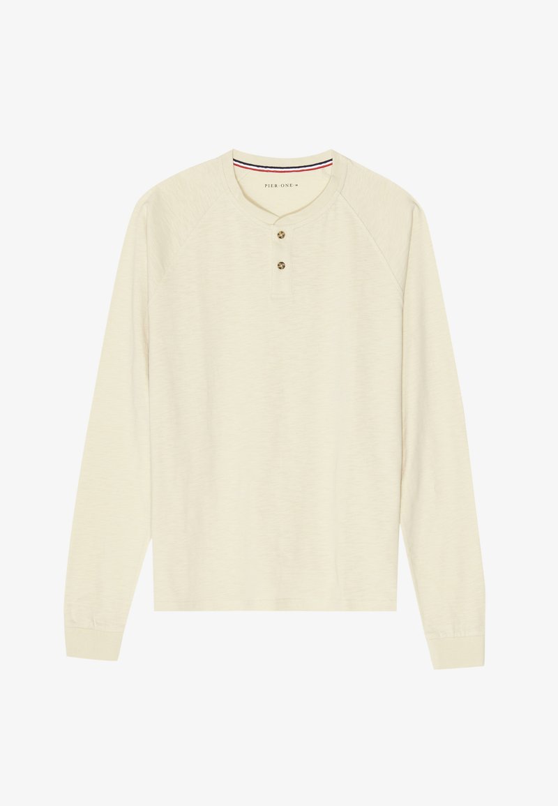 Henley majica z dolgimi rokavi v krem barvi, izdelana iz mehkega blaga, s rebrastim okroglim ovratnikom, dvogumbno zapenjanjem in raglan rokavi.
