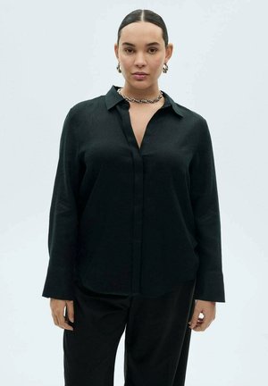 Black long-sleeve shirt with button-down collar, made of textured fabric, featuring a straight cut and relaxed fit, worn with matching pants.