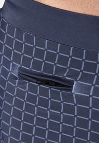 Navy patterned leggings with a grid design, featuring a small zippered pocket on the back and a smooth, stretchy waistband.
