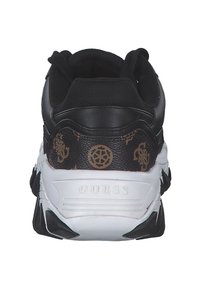 Sneaker nera con tomaia texture, dotata di un pannello marrone con motivo sul retro, suola intermedia bianca e dettagli neri sulla suola.