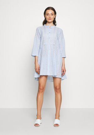 Vestido azul claro feito de algodão com detalhes em ilhós, apresentando uma frente com botões, colarinho e mangas de 3/4 de comprimento; silhueta semi-ajustada.