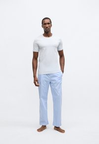 Vaaleanharmaa lyhythihainen t-paita pyöreällä pääntiellä yhdistettynä sinivalkoiseen ruudulliseen pyjamahousuun, joissa on rento istuvuus ja suorat lahkeet.