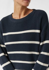 Granatowy sweter z dzianiny z białymi poziomymi pasami, charakteryzujący się szerokim okrągłym dekoltem i prążkowaną teksturą.